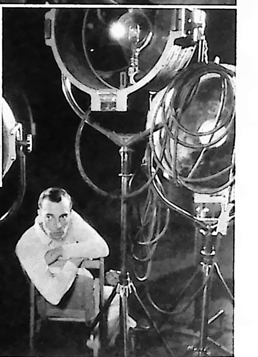Buster Keaton w atelier filmowym, otoczony wielkimi reflektorami