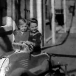 Dziecko w miniaturowym samochodziku na letniej alei, 1935