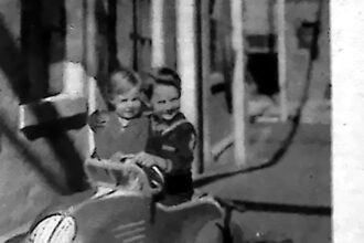 Dziecko w miniaturowym samochodziku na letniej alei, 1935