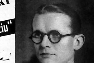 Portret mężczyzny w okularach i garniturze, zdjęcie prasowe z 1935 roku.