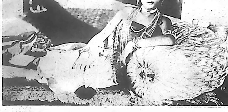 Hinduska aktorka w bogatej biżuterii, spoczywająca na poduszkach — primadonna pierwszego filmu kręconego w Indiach Wschodnich. Fotografia z 1926 r.