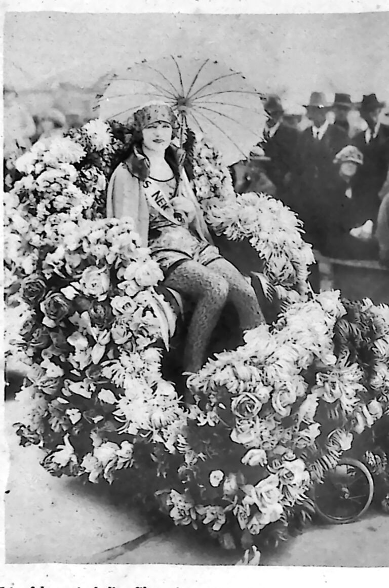 Aktorka Viola Dana z parasolką, siedząca na przystrojonym kwiatami wozie podczas korowodu w Hollywood. Fotografia z 1926 r.