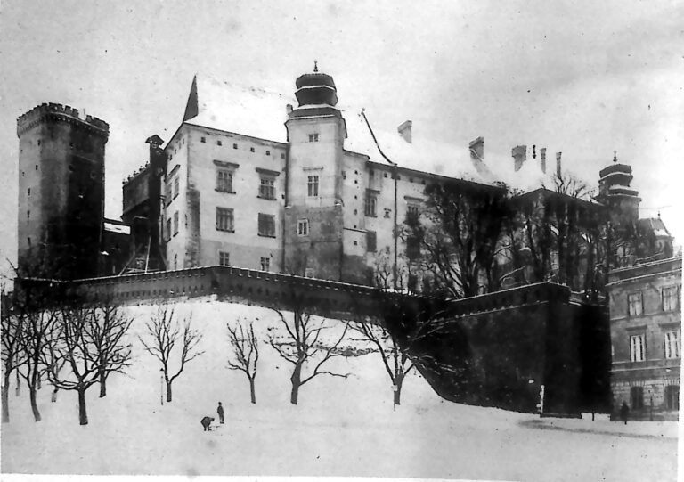 Zimowy widok Zamku Królewskiego na Wawelu w Krakowie od strony Stradomia, ze wzgórzem i drzewami pokrytymi śniegiem. Fotografia z 1926 r.