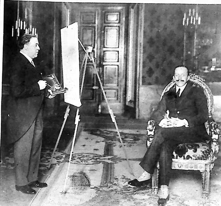 Malarz przy sztalugach w bogato urządzonej sali; po prawej król Alfons XIII siedzący w fotelu i pozujący do portretu. Fotografia z 1926 r.