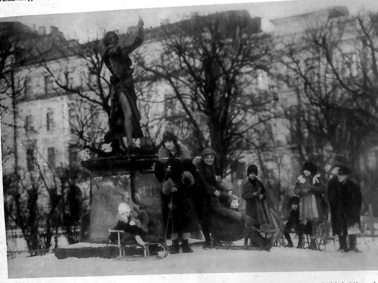 Dzieci z sankami przy pomniku Lilli Wenedy na Plantach w Krakowie zimą, wśród bezlistnych drzew. Fotografia z 1926 r.
