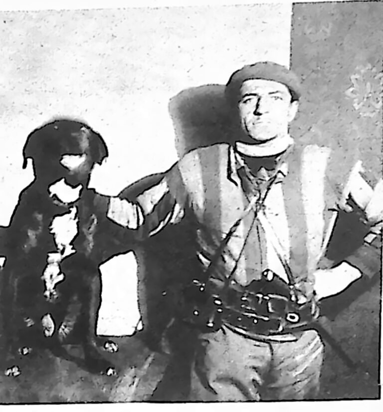 Mężczyzna w berecie i wędrownym stroju z psem — inwalida wojenny Edmund Caradec podczas pieszej podróży po Europie. Fotografia z 1926 r.