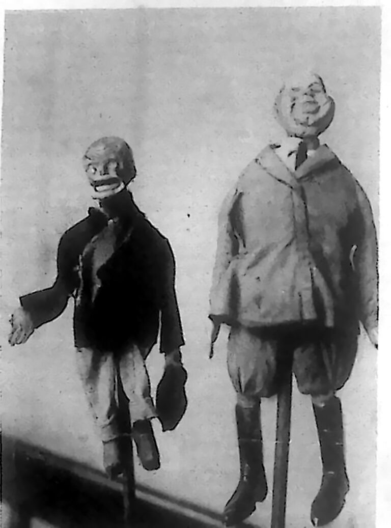Dwie kukiełki szopkowe zawieszone na prętach, sfotografowane za kulisami szopki w warszawskiej Szkole Sztuk Pięknych. Fotografia z 1926 r.