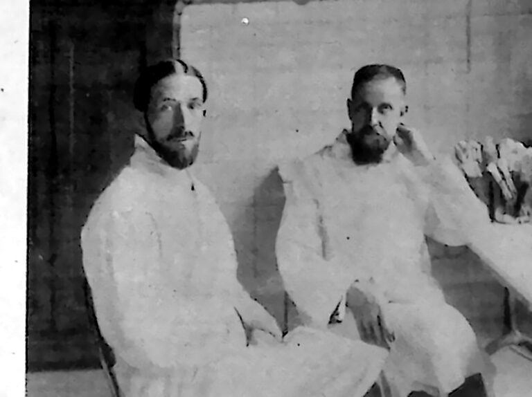 Dwaj uczeni w białych fartuchach przy stole laboratoryjnym Instytutu Pasteura w Paryżu. Fotografia z 1926 r.