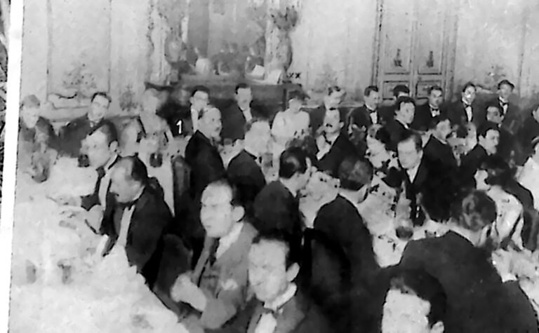 Uczestnicy bankietu Międzynarodowej Federacji Studentów przy stołach w paryskiej sali. Fotografia z 1926 r.