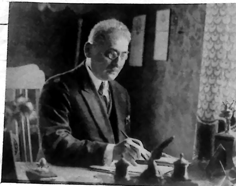 Mężczyzna w okularach przy biurku, z piórem w dłoni — intendent szpitala żydowskiego w Warszawie I. Fliederbaum. Fotografia z 1926 r.