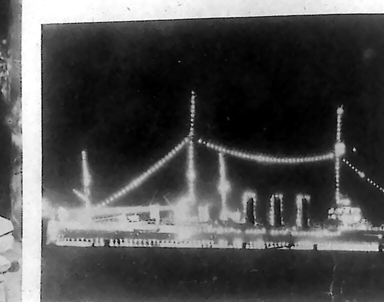 Krążownik „Strassburg” nocą, obrysowany sznurami świateł od dziobu po rufę. Fotografia z 1926 r.