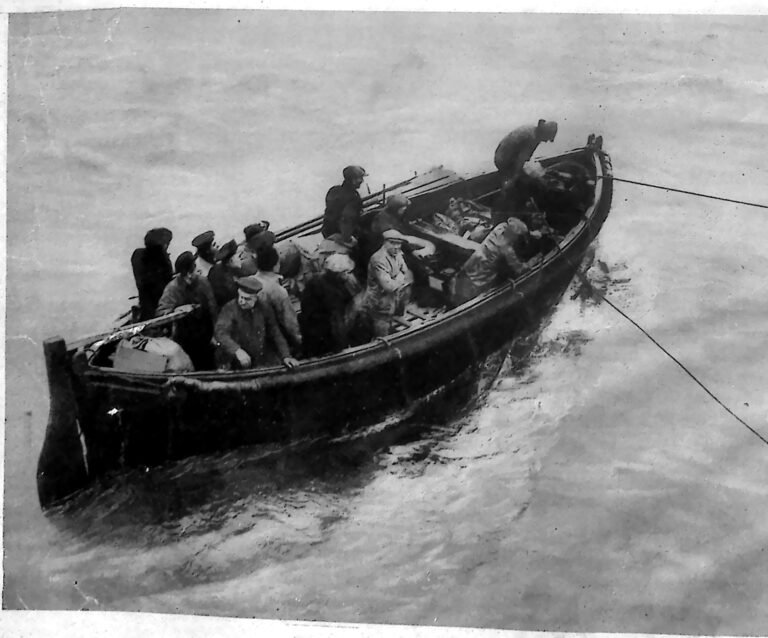 Przepełniona ludźmi łódź wiosłowa na wzburzonym morzu, holowana na linach. Fotografia z 1926 r.