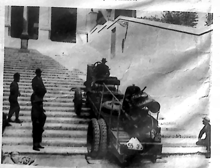 Samochód wjeżdżający po stromych kamiennych schodach do kościoła Ara Coeli w Rzymie, obserwowany przez przechodniów. Fotografia z 1926 r.