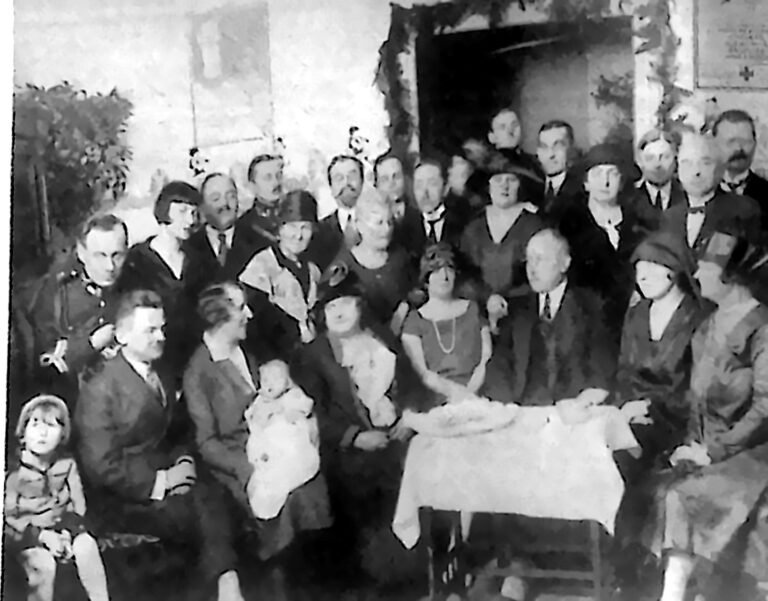 Tłum gości i dzieci w udekorowanej sali podczas otwarcia przychodni „Kropla mleka” w Łodzi. Fotografia z 1926 r.