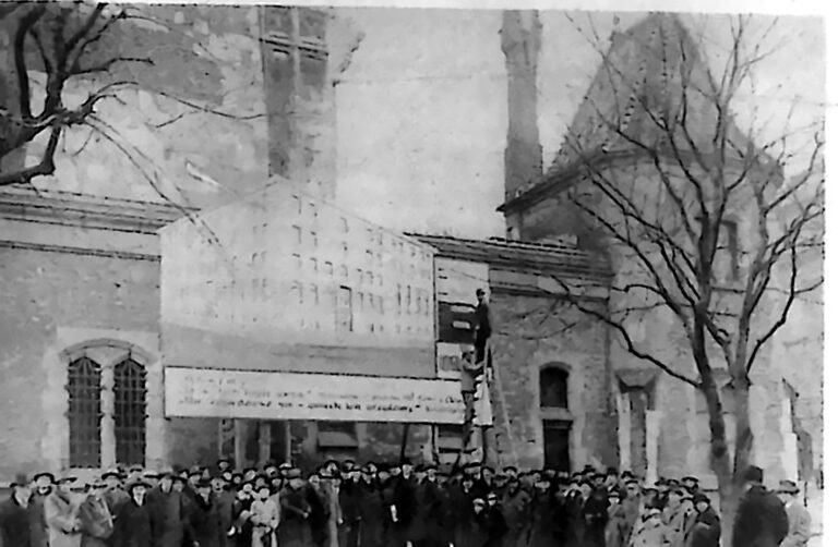 Tłum przed transparentem zawieszonym pod wieżą ratuszową na krakowskim Rynku. Fotografia z 1926 r.