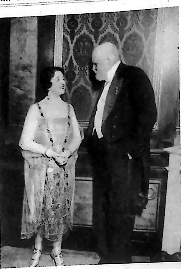 Starszy mężczyzna we fraku rozmawiający z kobietą w długiej sukni wieczorowej na raucie w Wiedniu. Fotografia z 1926 r.
