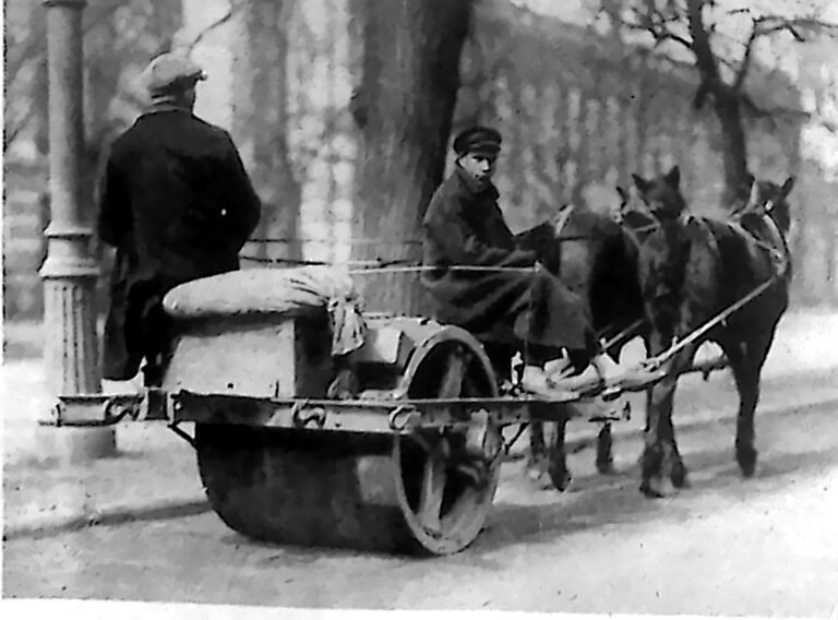 Konny walec drogowy na ulicy Warszawy, obsługiwany przez dwóch robotników. Fotografia z 1926 r.