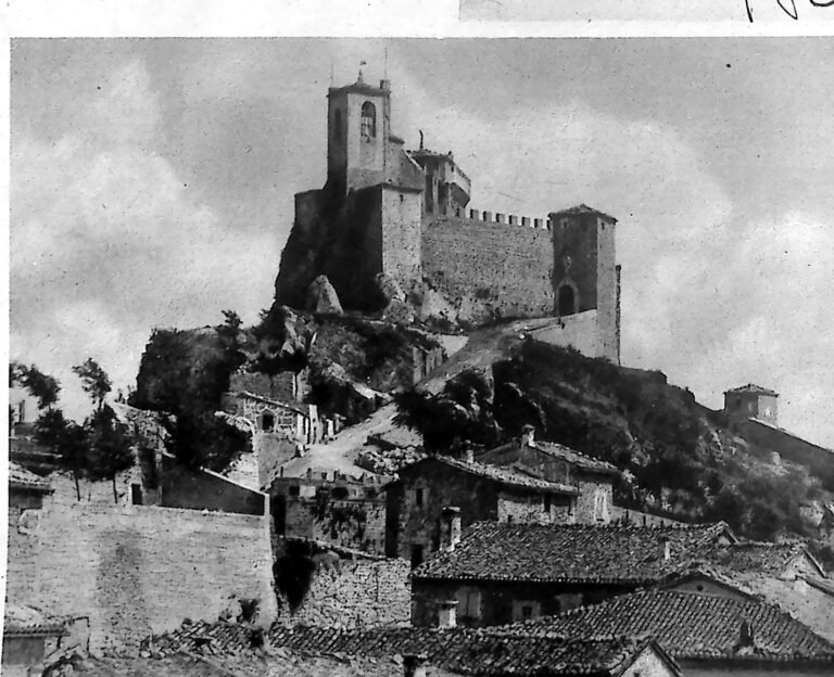 Średniowieczna wieża i mury cytadeli San Marino na skalistym wzgórzu, poniżej dachy miasteczka. Fotografia z 1926 r.