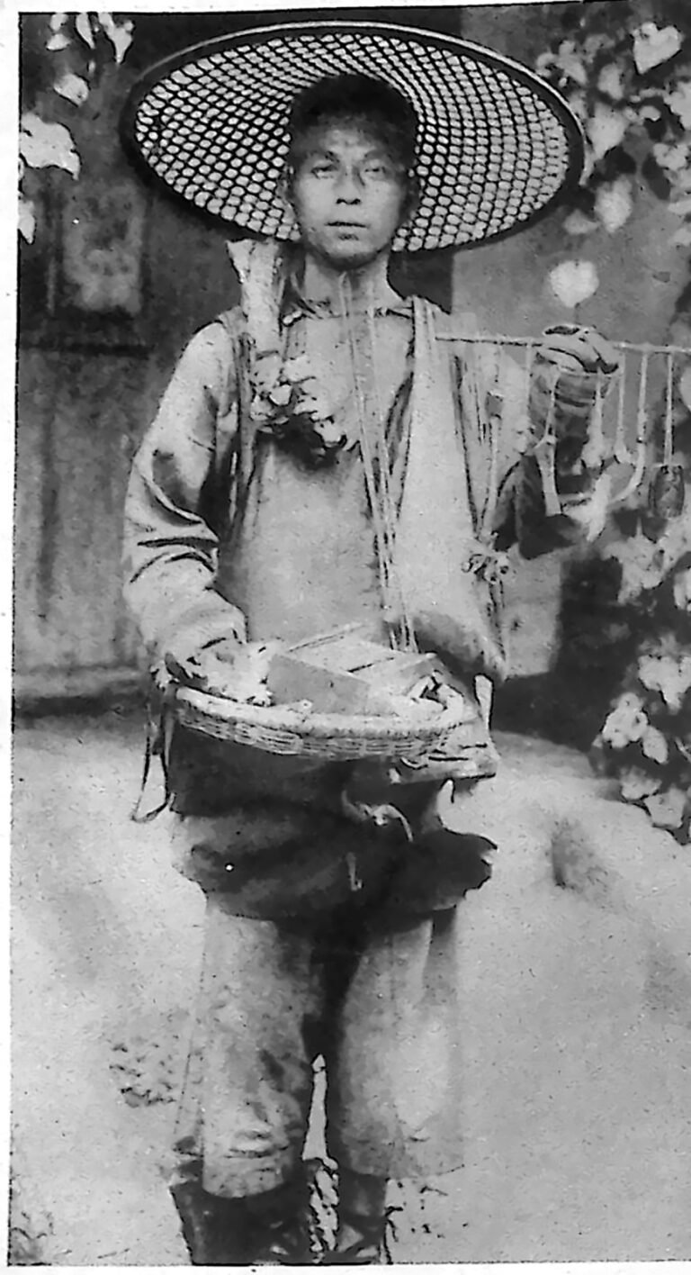 Wędrowny handlarz w ogromnym plecionym kapeluszu, z koszem towaru zawieszonym na szyi. Fotografia z 1926 r.