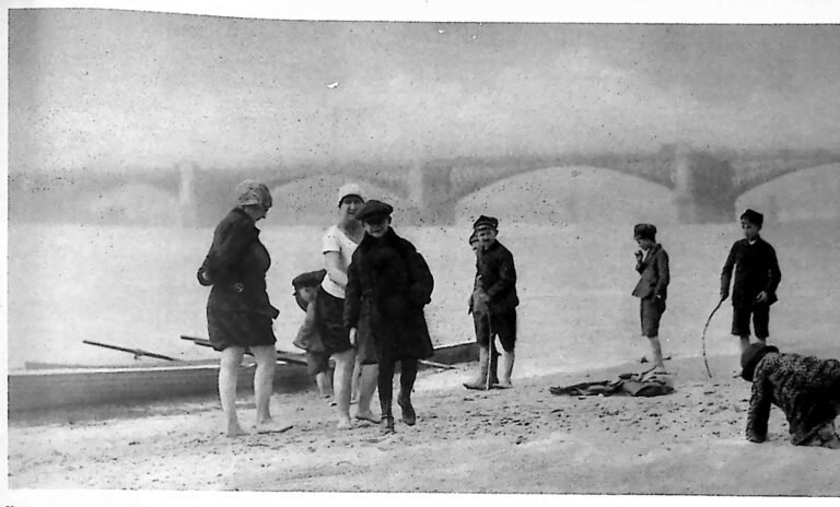 Dzieci i dorośli na piaszczystej łasze nad Wisłą, w tle przęsła mostu. Fotografia z 1926 r.