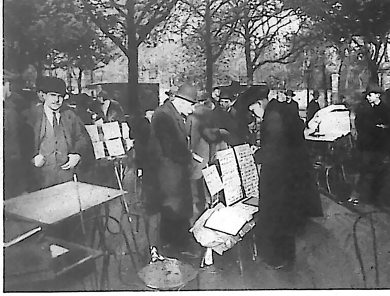 Handlarze znaczków z rozłożonymi klaserami na stołkach pod drzewami przy Polach Elizejskich. Fotografia z 1926 r.