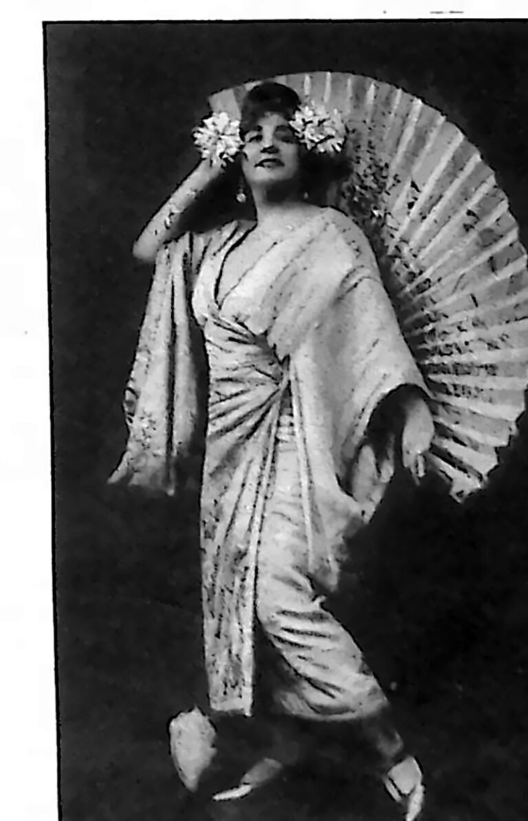 Śpiewaczka operetkowa w jasnej sukni i kwiatach we włosach, z rozłożonym wachlarzem. Fotografia z 1926 r.