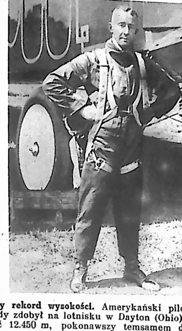 Pilot w futrzanym kombinezonie lotniczym stojący przy samolocie. Fotografia z 1926 r.