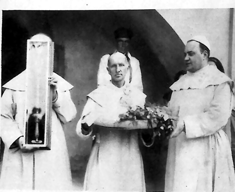 Zakonnicy paulińscy w białych habitach, trzymający gablotę i tacę z insygniami koronacyjnymi. Fotografia z 1926 r.