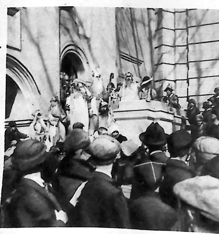 Tłum widzów i uczestnicy widowiska w strojach historycznych przed gotyckim portalem w Wilnie. Fotografia z 1926 r.