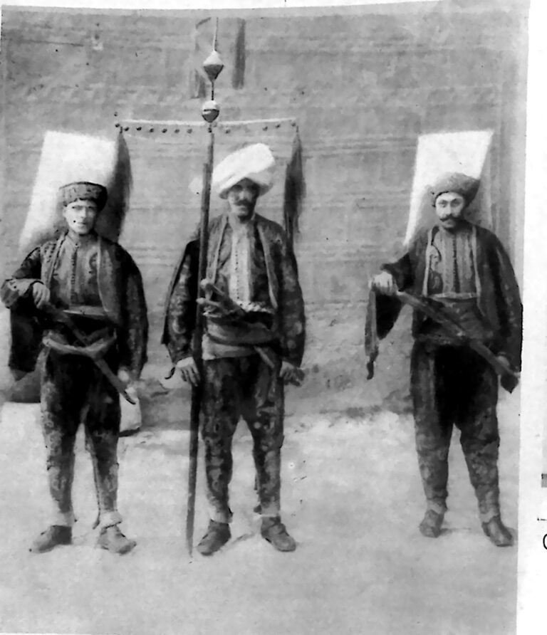 Trzej żołnierze w historycznych strojach jańczarskich z bronią i buńczukiem. Fotografia z 1926 r.