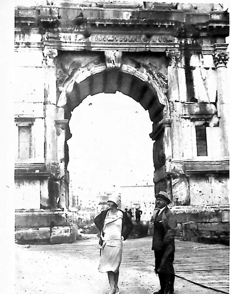 Kobieta w jasnej sukni i kapeluszu oraz mężczyzna w płaszczu na tle Łuku Tytusa w Rzymie. Fotografia z 1926 r.