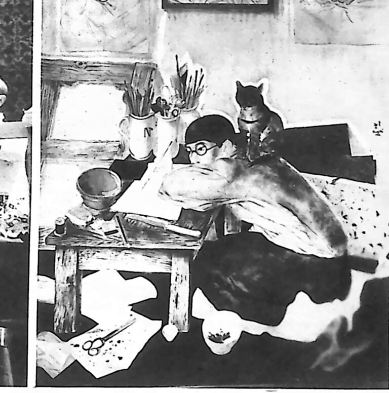 Autoportret Tsuguharu Foujity: malarz w okularach przy stole z pędzlami, z kotem na ramieniu. Fotografia z 1926 r.