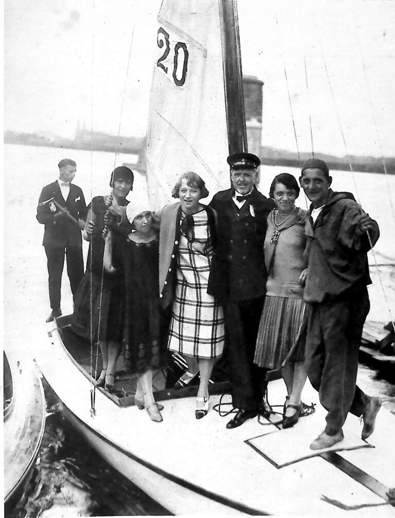 Grupa pań i panów pozujących na pokładzie żaglówki z numerem 20 na żaglu, na Wiśle. Fotografia z 1926 r.